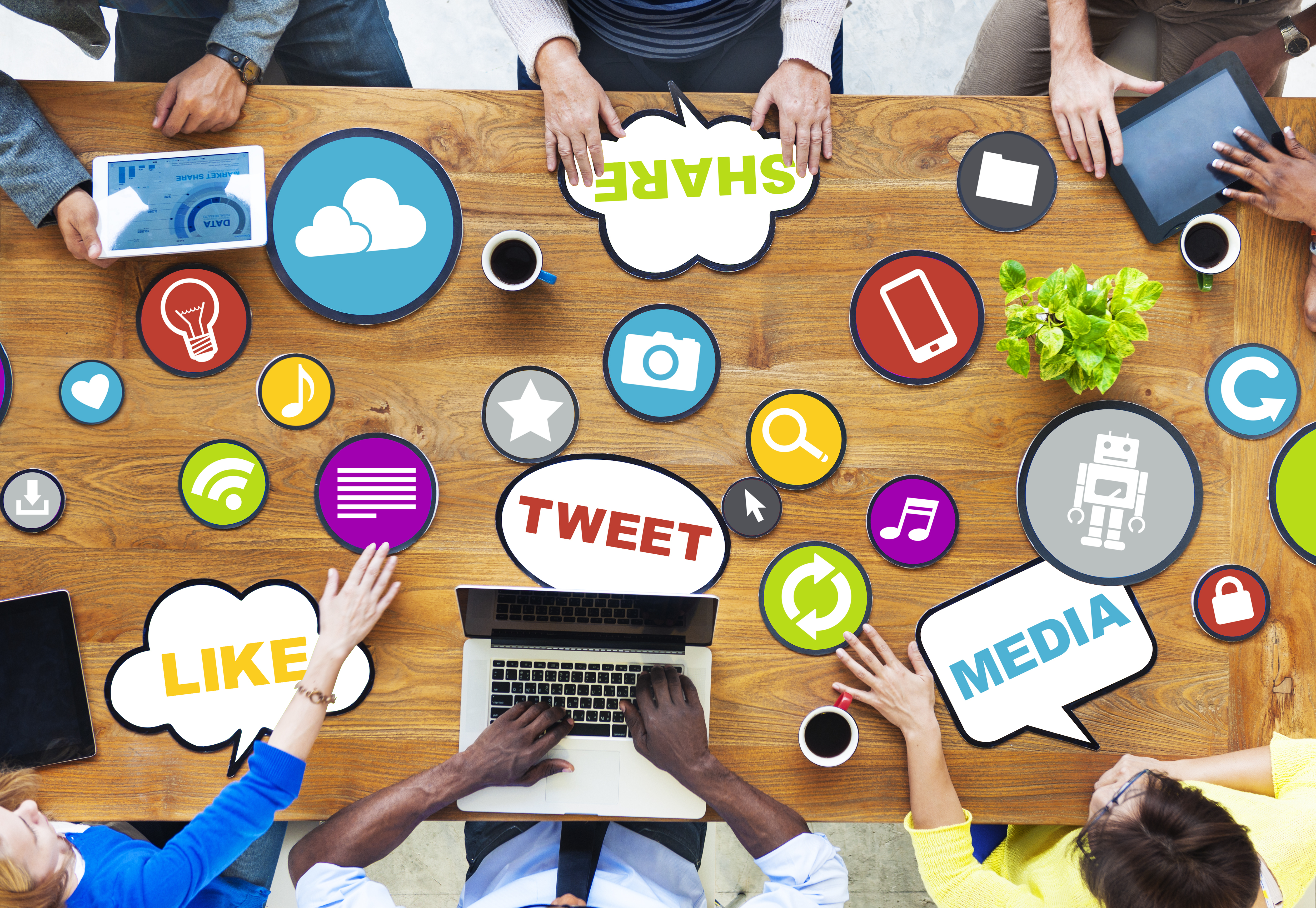 A work meeting at a table with various social media text bubble stickers on the table.