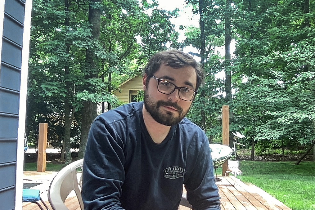 A simple photo of myself self sitting outside with trees in the background